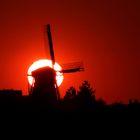 alte holländische Windmühle vor untergehender Sonne