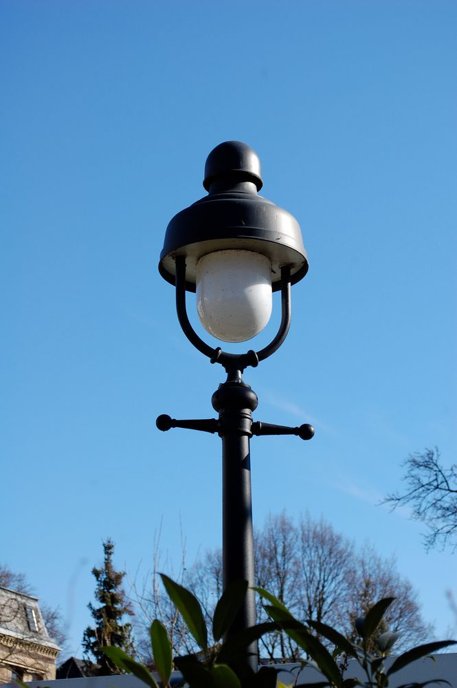 Alte Laterne vor strahlend blauem Himmel.