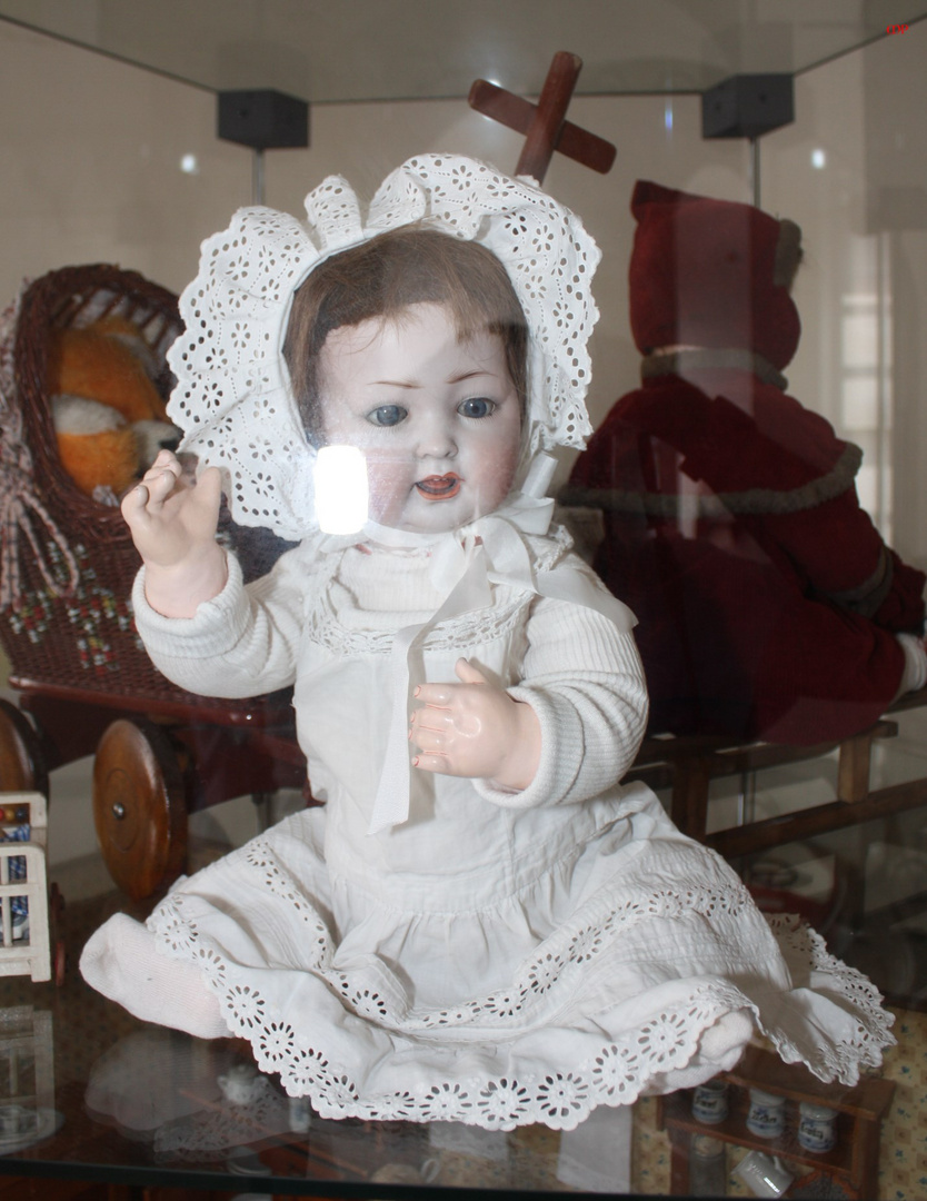 alte Spielzeug-Babypuppe in der Vitrine