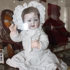 alte Spielzeug-Babypuppe in der Vitrine