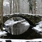 Alte Steinbrücke über den Bach im Winter