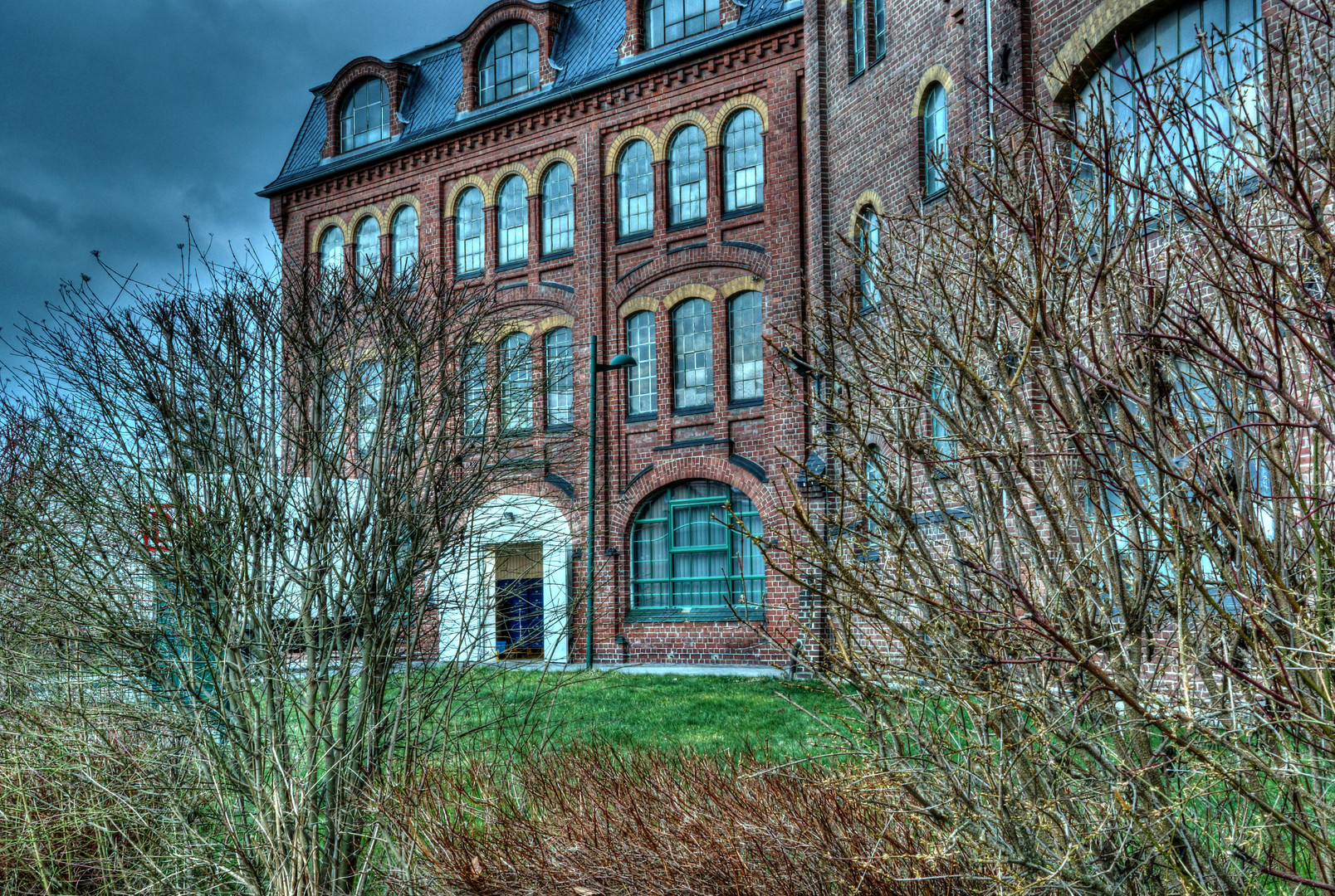 Alte Textilfabrik hinter Büschen in Zittau