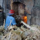 alter Mann beim Feuer einheitzen in der Zuckerrohrfabrik