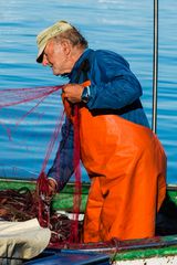 Alter Mann kontrolliert die Fischnetze...