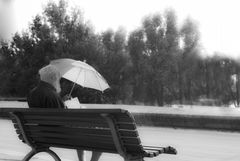 Alter Mann mit Regenschirm und Buch