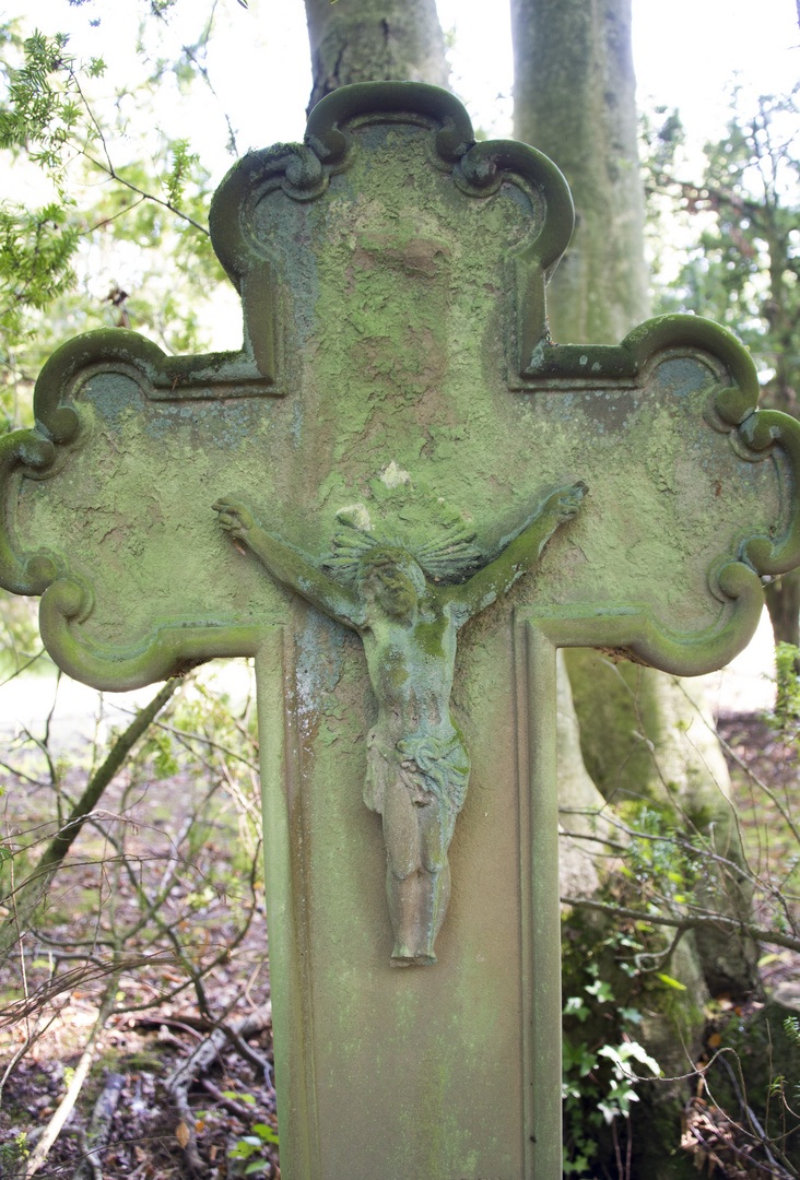 alters Grabkreuz im Wald