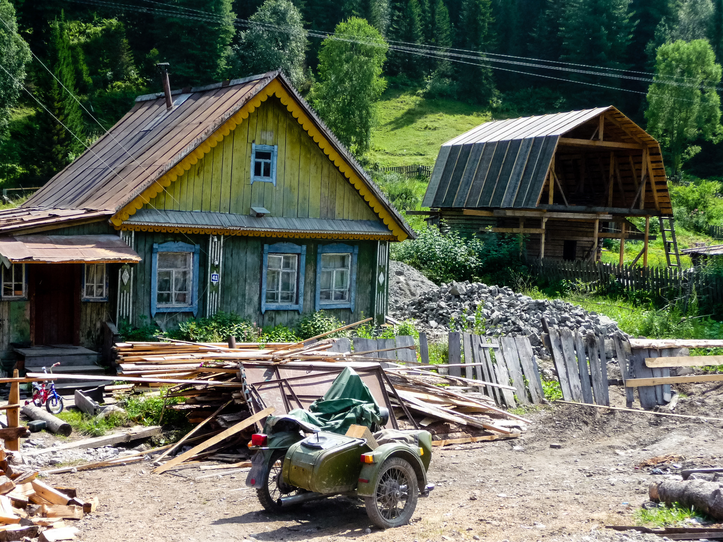 altes russisches Motorrad mit Beiwagen vor Häuschen