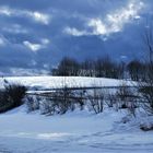 Altschnee glänzt unter den Wolken