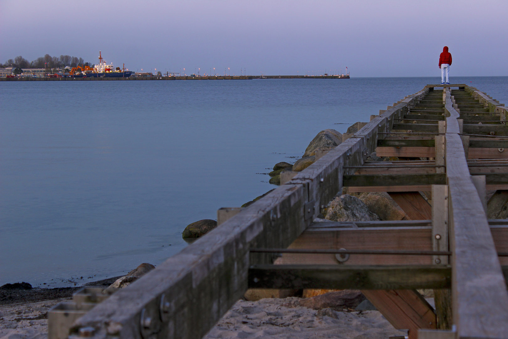 Am Ende des Steges, den Blick auf das Meer gerichtet