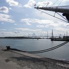 Am Hafen - Im Hintergrund neue, über 4000 m lange Rügenbrücke - vorn Bug von Gorch Fock