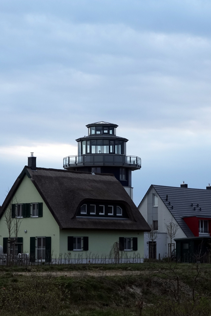 am Haus ,ein Leuchtturm steht.