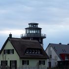 am Haus ,ein Leuchtturm steht.