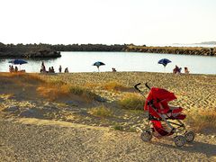 Am Strand - roter Kinderwagen / In spiaggia - il passeggino rosso