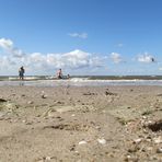 am Strand und im Wasser viele Menschen