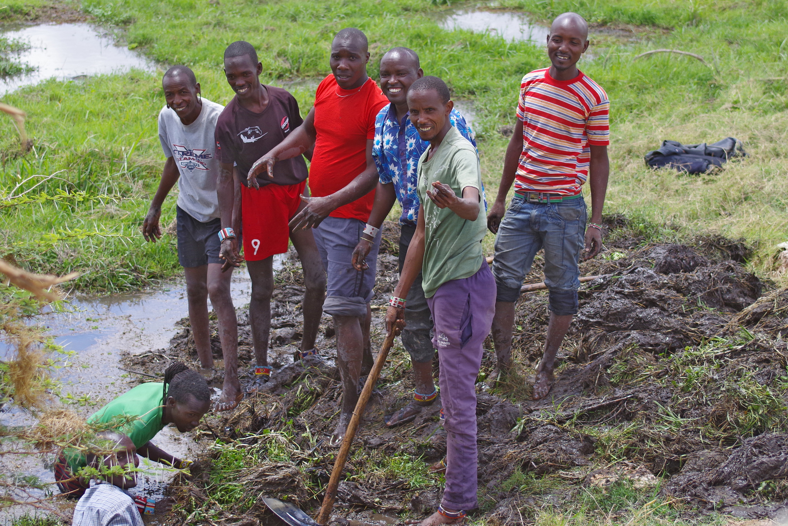 Amboseli NP  Arbeiter befreien ein Entwässerungsrohr von Pflanzen