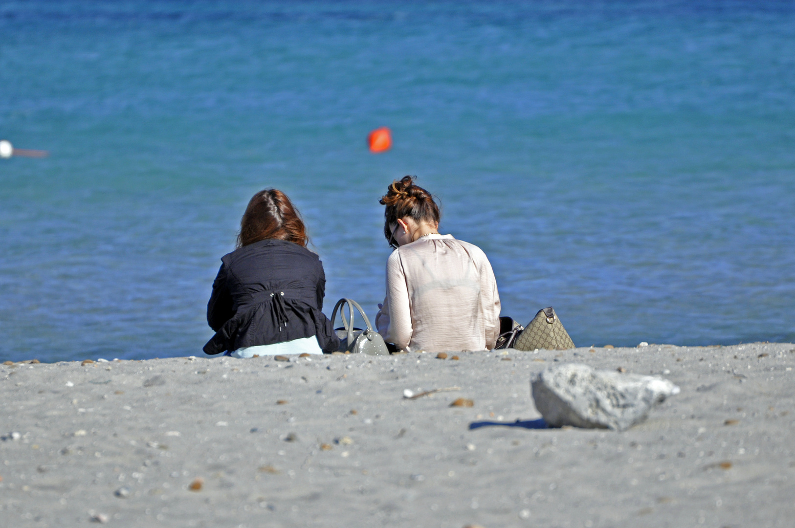 Amiche in spiaggia alla brezza primaverile