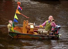 Amsterdam: ein Spaßmacher in seinem Schiffchen unterhält die Passanten köstlich