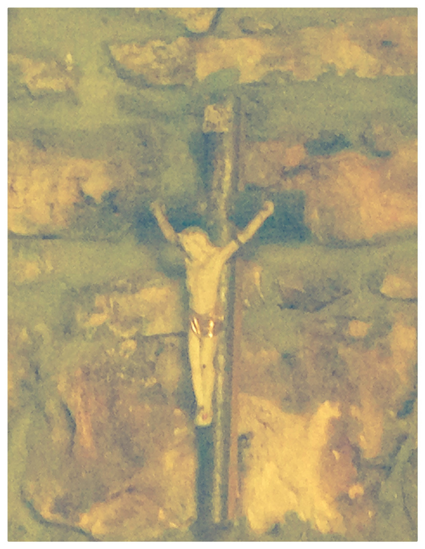 An einer Steinwand in einem alten kroaitischen Haus hängt das schöne Kreuz