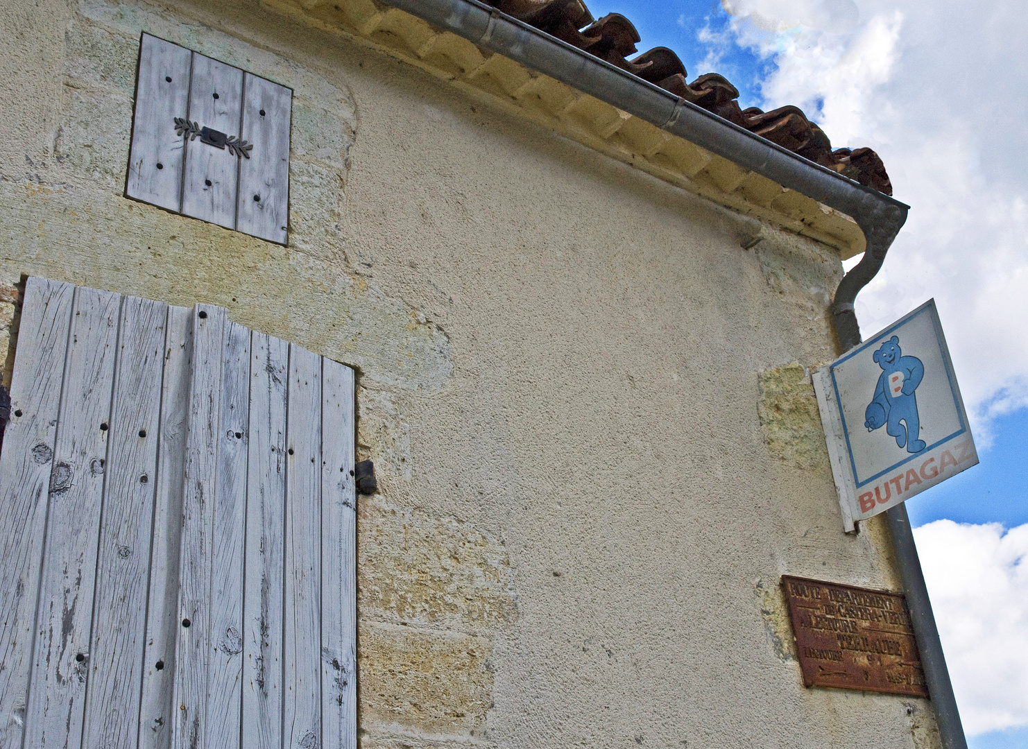 Anciens volets, plaque de signalisation et réclame