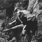 André de Dienes: “Model in net stockings posing on rock”, ca 1950
