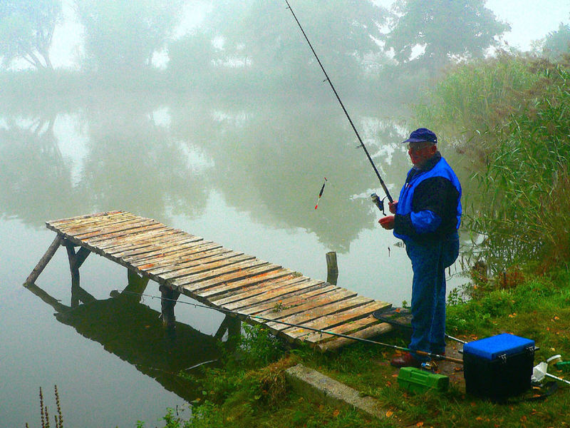 Angler am nebligen Herbsttag