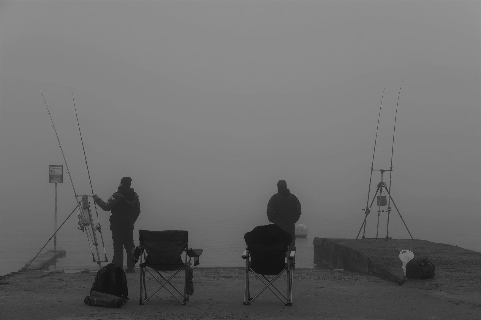 Angler an der See bei dichten Nebel.