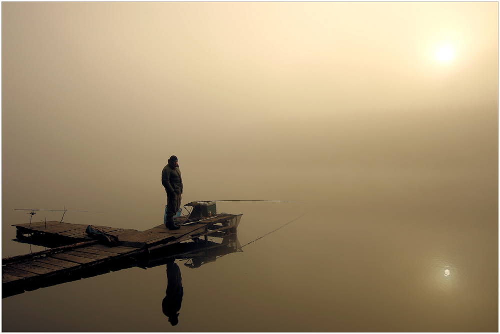 Angler im Nebel bei Sonnenaufgang