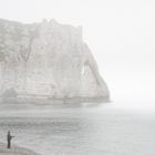 Angler im Nebel mit roter Tasche