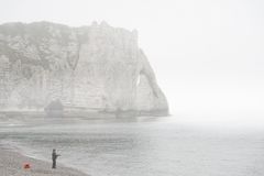 Angler im Nebel mit roter Tasche