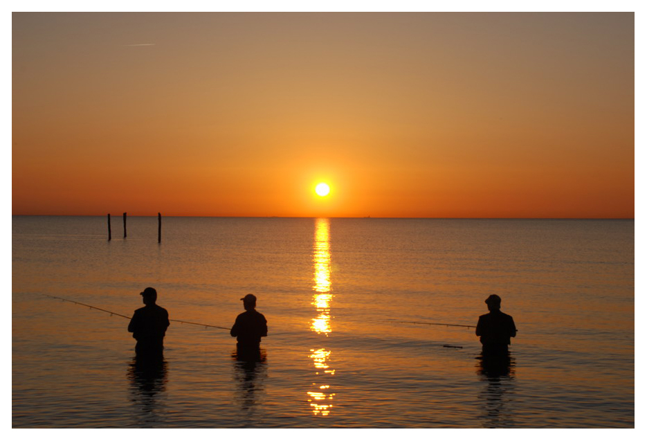 Angler in der Ostsee bei Sonnenuntergang