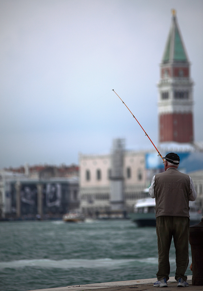 Angler vor der Silhouette von Venedig