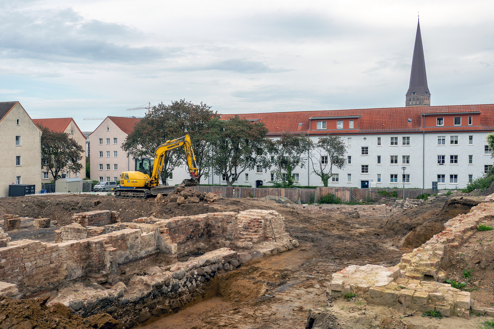 Archäologen und Kampfmittelräumer untersuchen Baugrube für Rathausanbau in Rostock