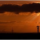 artifical sunrays bursting through cloud in a scenery with a lot of towers creating an orange soup