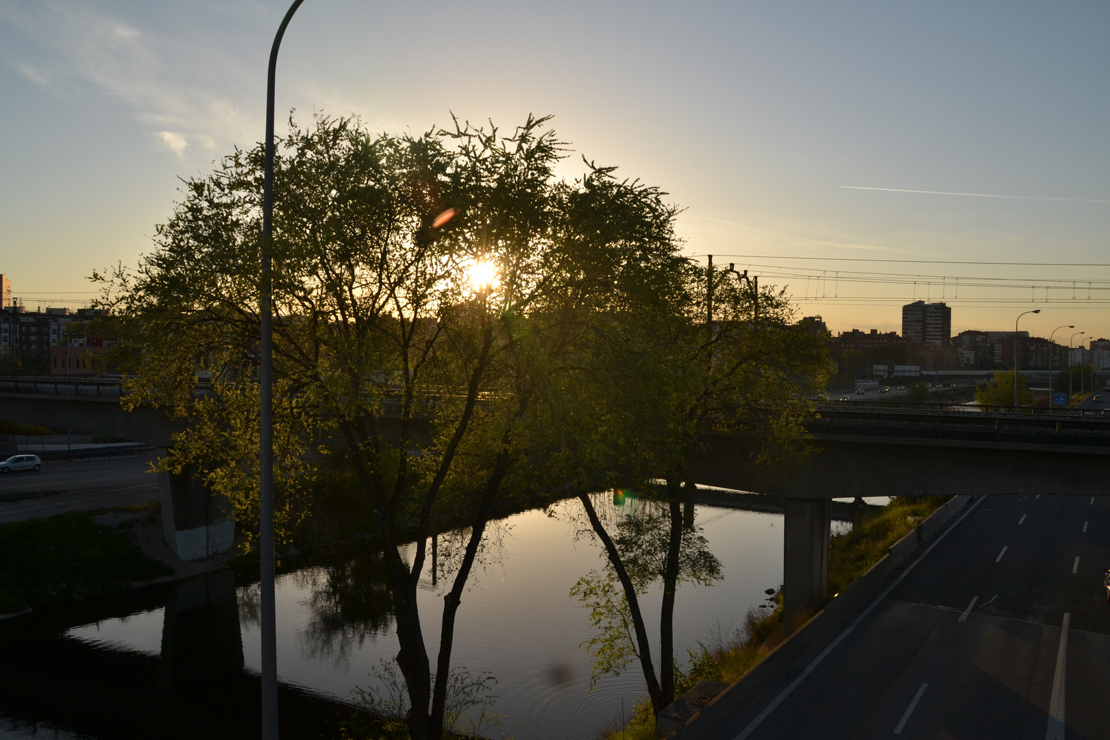 Atardecer sobre el asfalto y el rio