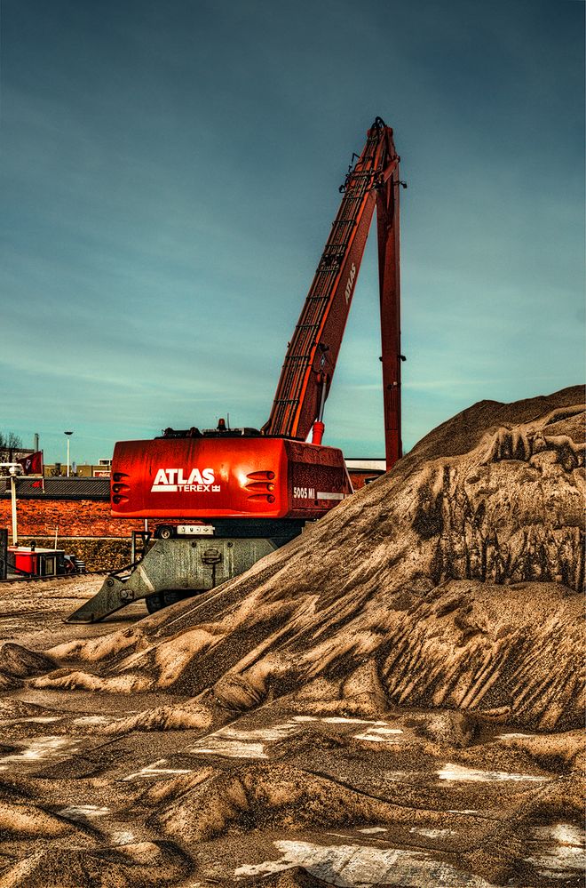 Atlas Bagger vor Sandhaufen