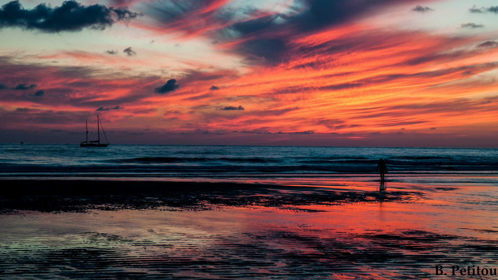 Au coucher de soleil, un surfeur sort de l'eau