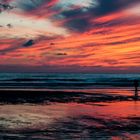 Au coucher de soleil, un surfeur sort de l'eau