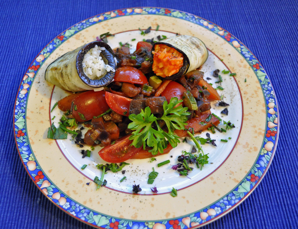 Auberginenröllchen mit Reis gefüllt auf Zucchini-Auberginen-Tomaten-Rotwein-Ratatouille