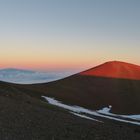 Auf 4205 Metern, wirft die untergehende Sonne des Schatten des Mauna Kea auf die Wolken.