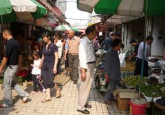 Auf dem Markt: Nur das kleine Maedchen ist nicht so recht bei der Sache