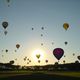 Aufstieg von 48 Heilutfballons im Gegenlicht