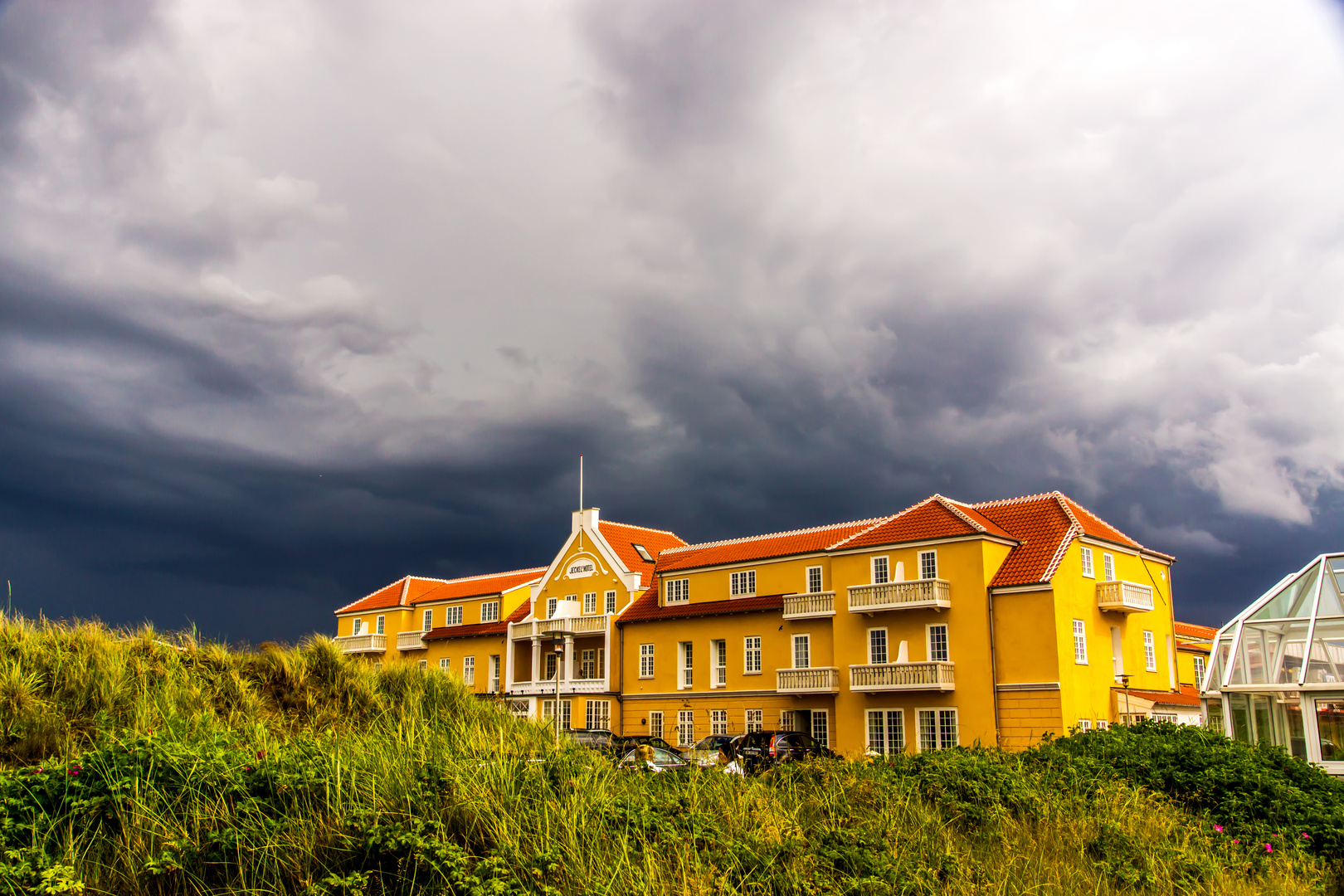 Aufziehendes Unwetter mit Gewitter und Starkregen vor einem Luxushotel in Skagen.