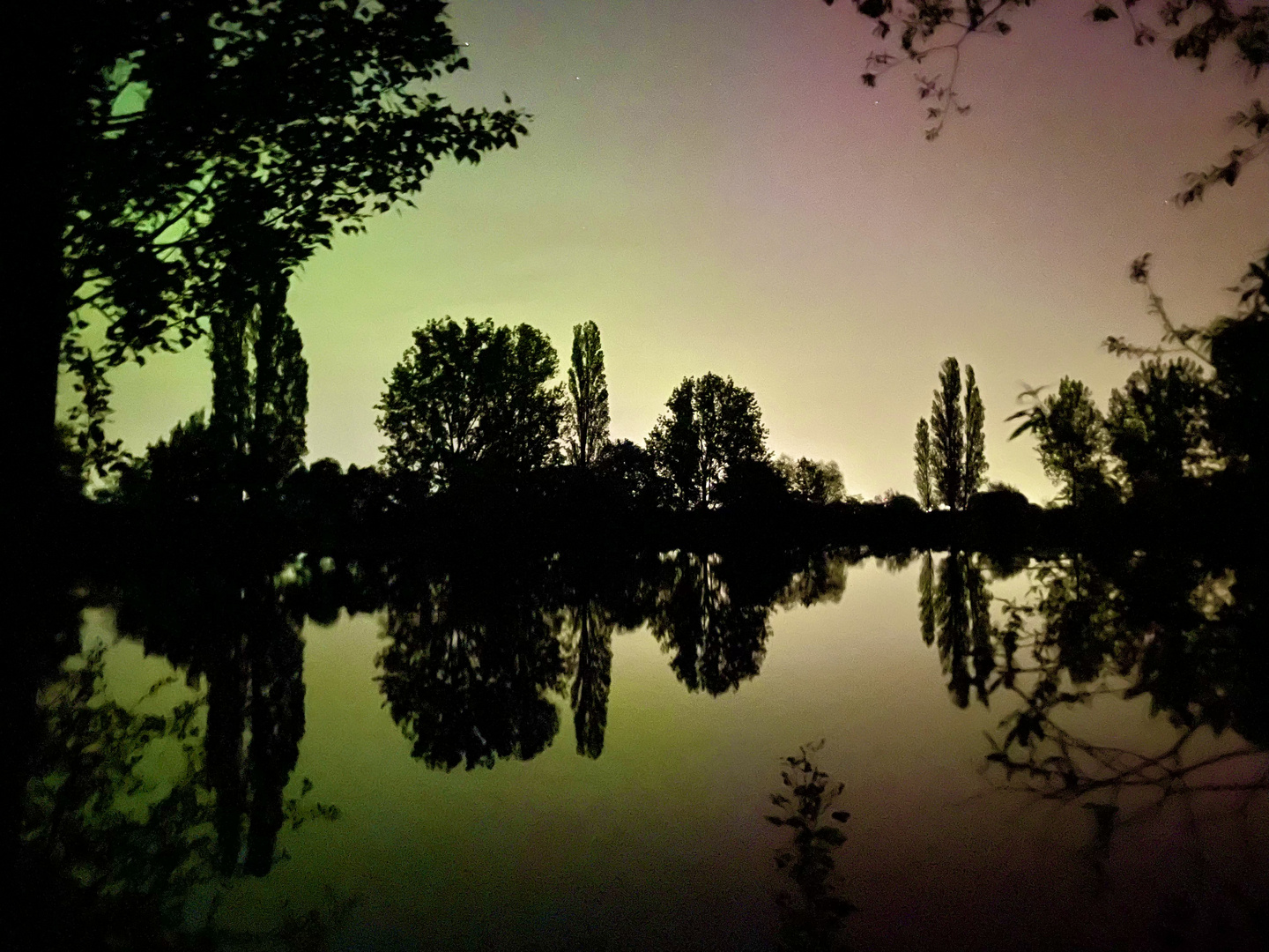 Aurora Borealis verfärbt die Nacht am See 