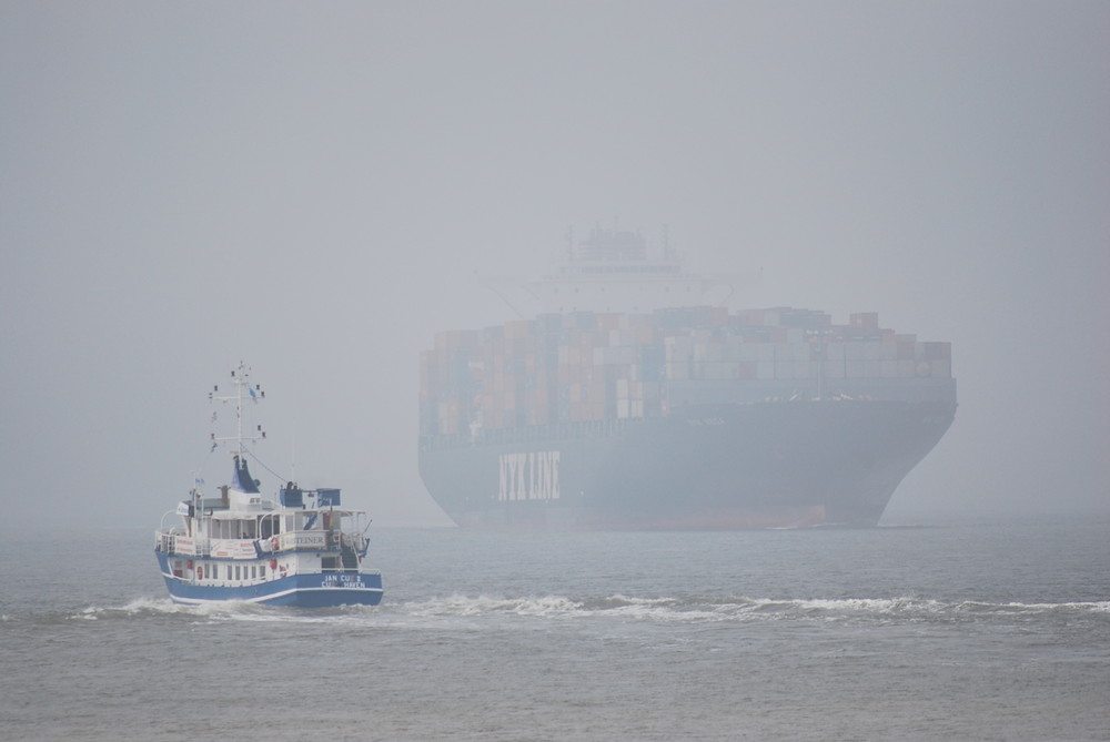 Aus dem Nebel kommt ein Containerschiff