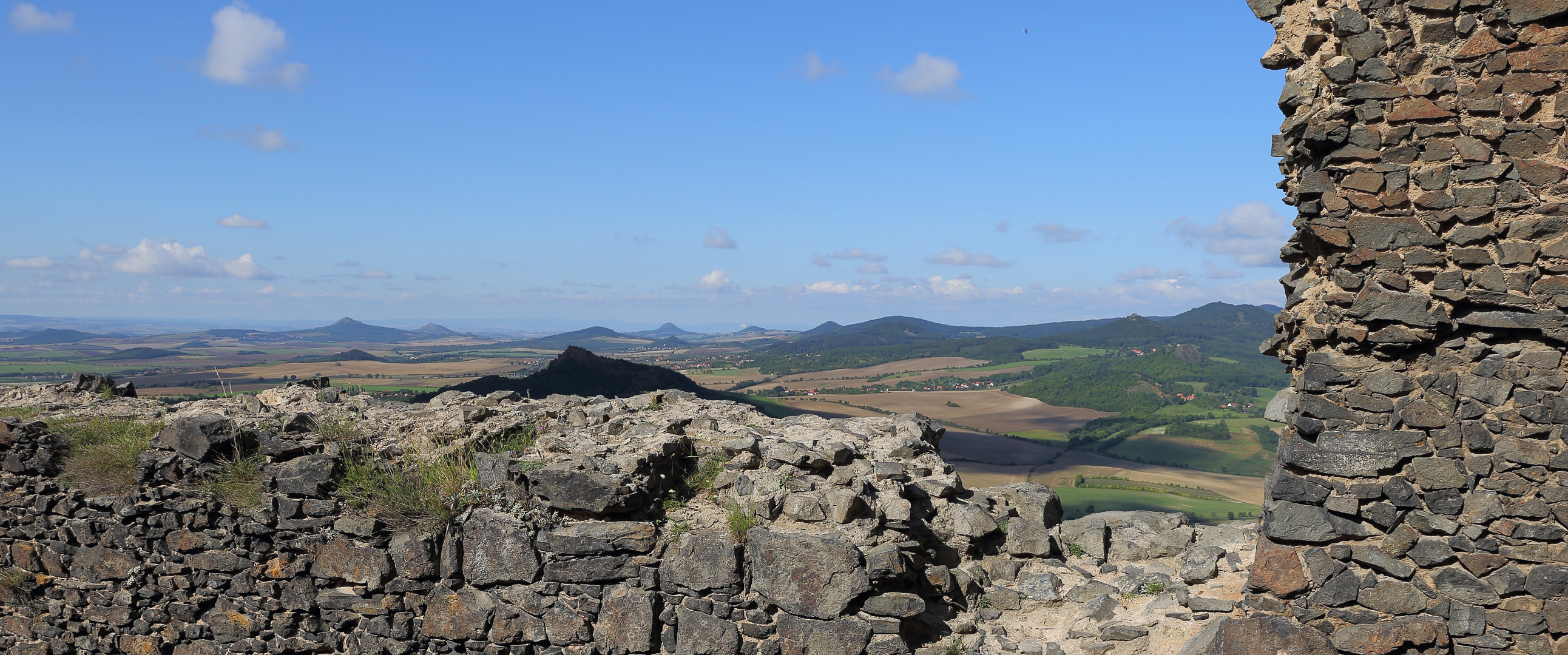 Aus der Burgruine des Kostalov über die Mauer zu den Steppenbergen