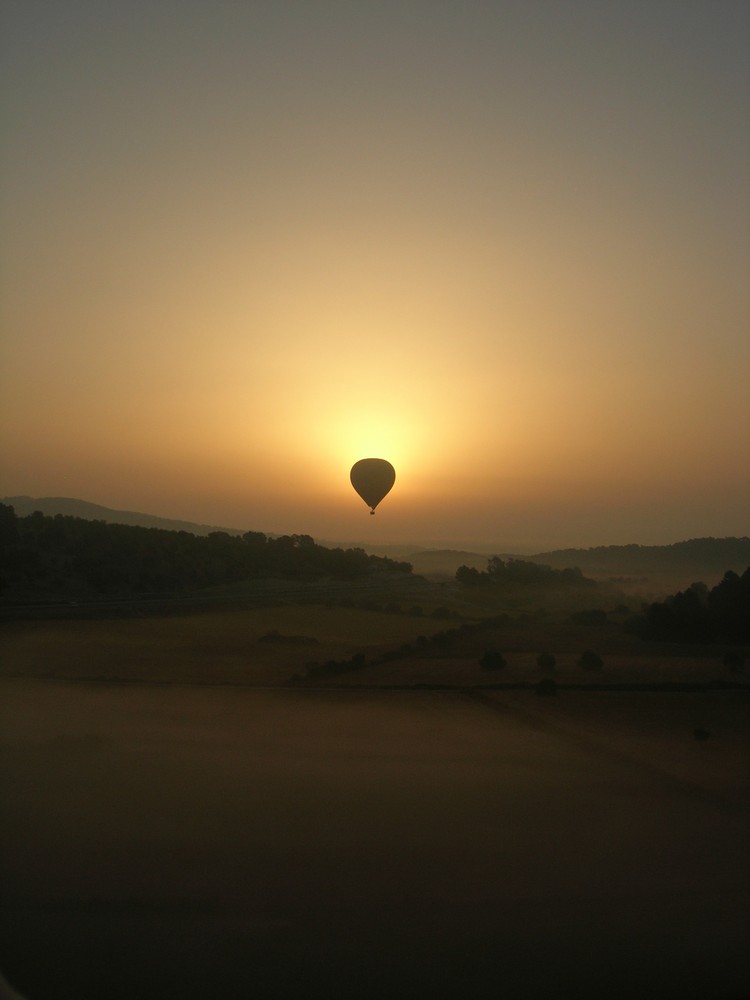 Aus einem Heißluftballon am frühen Morgen das Land erwachen zu sehen