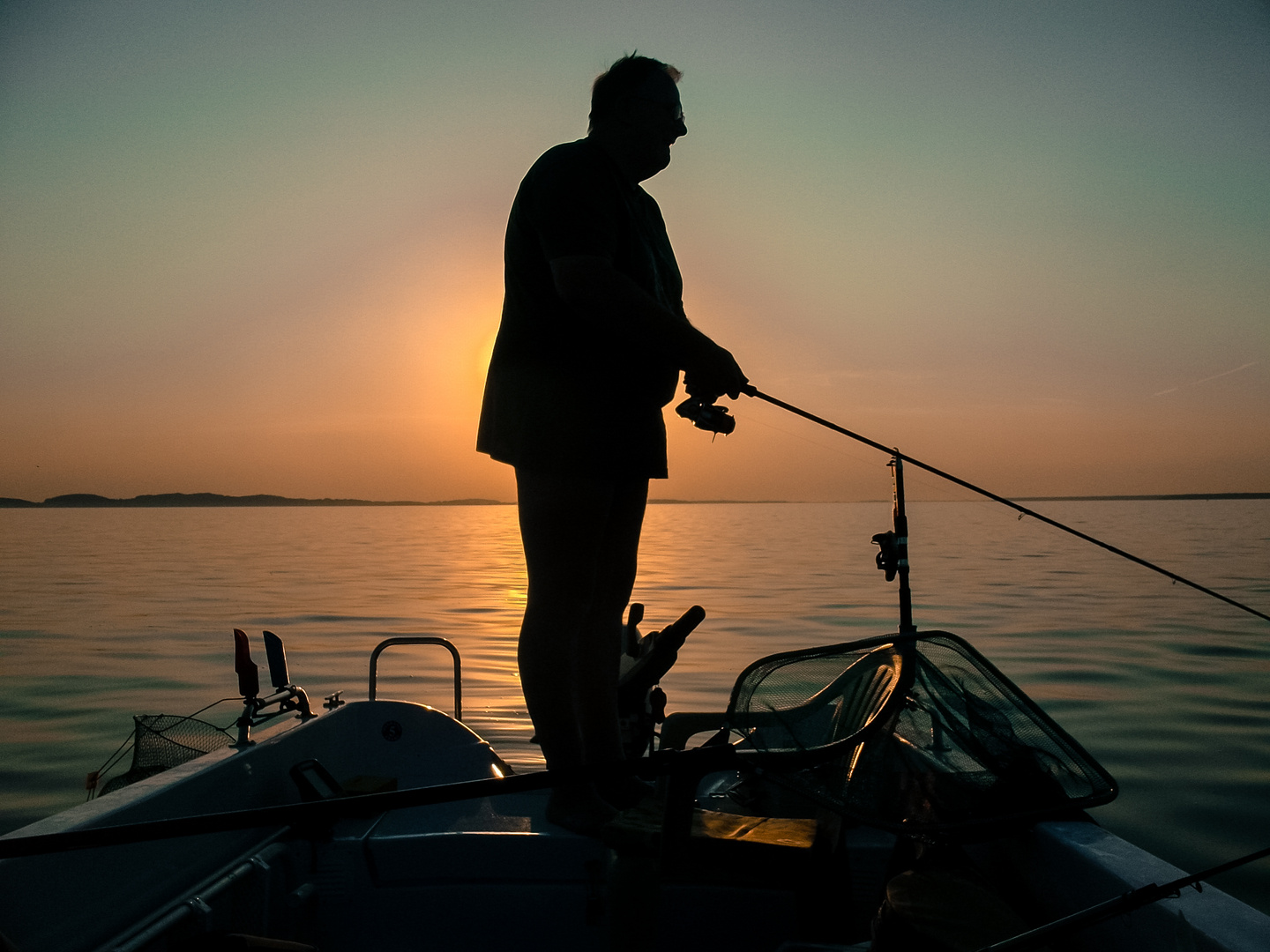 ausdauernder Angler bei Sonnenuntergang