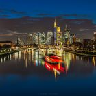 Ausflugsdampfer vor der Skyline von Frankfurt zur blauen Stunde