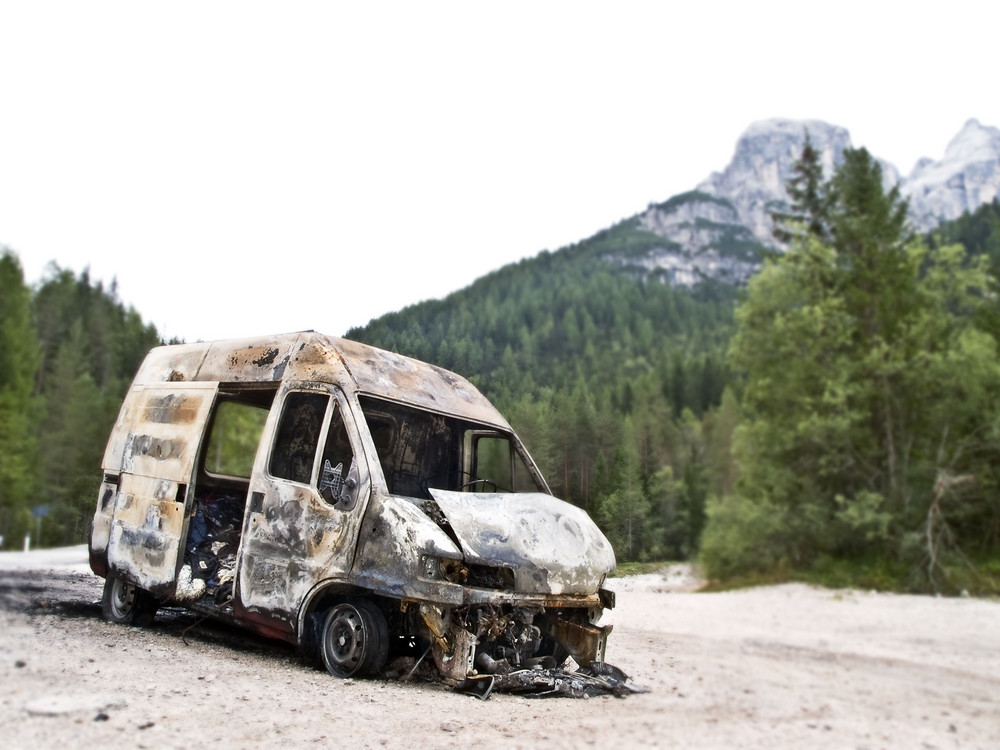 Ausgebrannter Lieferwagen am Straßenrand in den Dolomiten