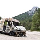 Ausgebrannter Lieferwagen am Straßenrand in den Dolomiten